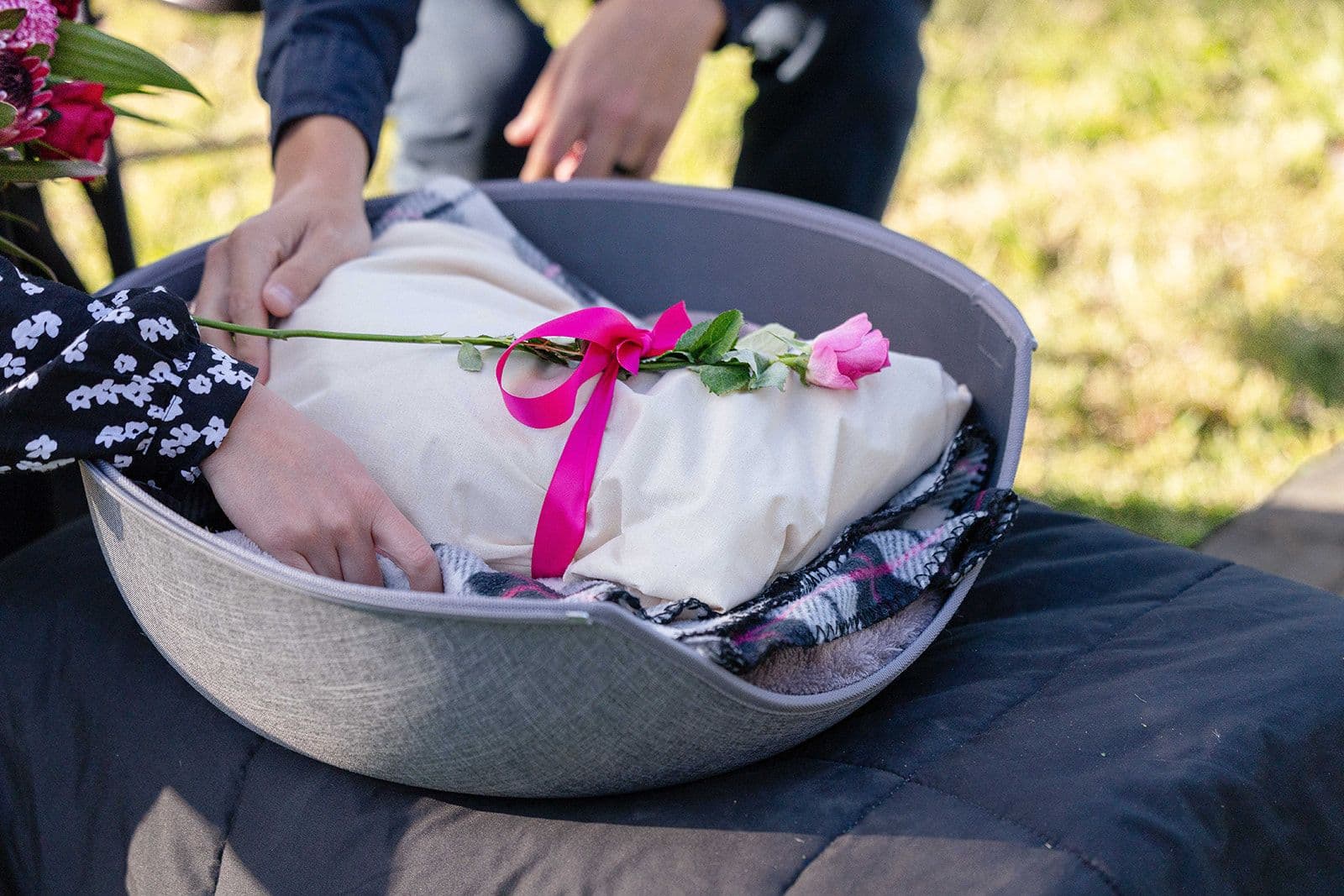 A soft shroud tied with ribbon and a rose